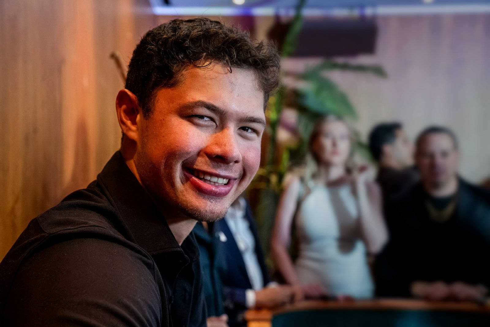 A smiling US Casino Rentals dealer at a casino party table, with guests behind him